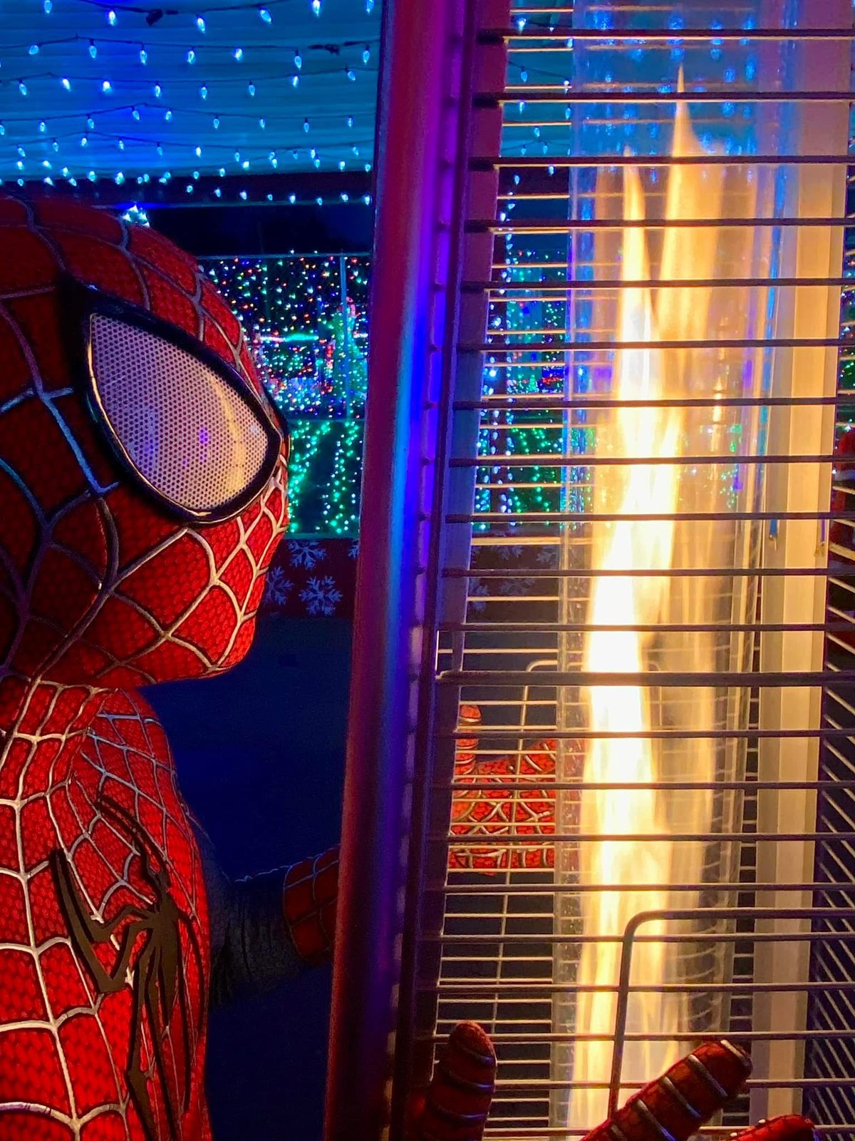 Costumed character beside a heater and colorful holiday lights in a past season